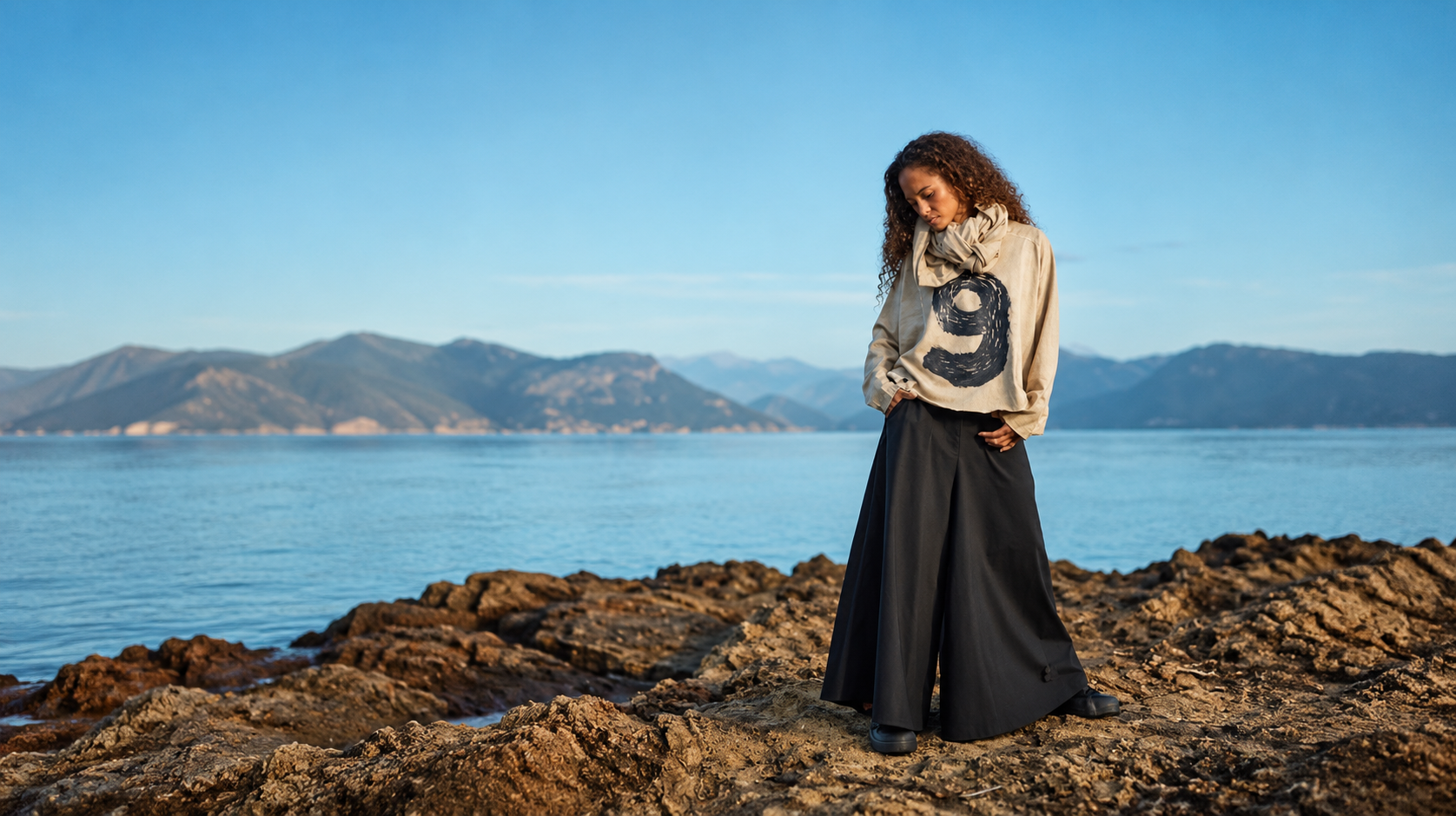 Model aan zee met baggy kleding